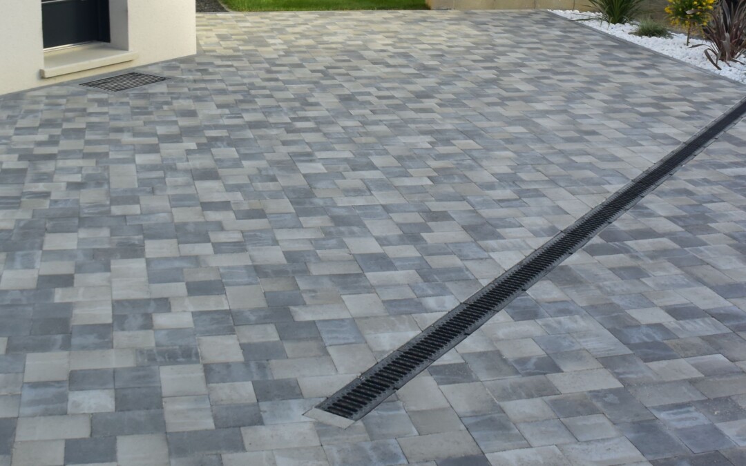 Terrasse en pavés de béton gris avec une grille d'évacuation