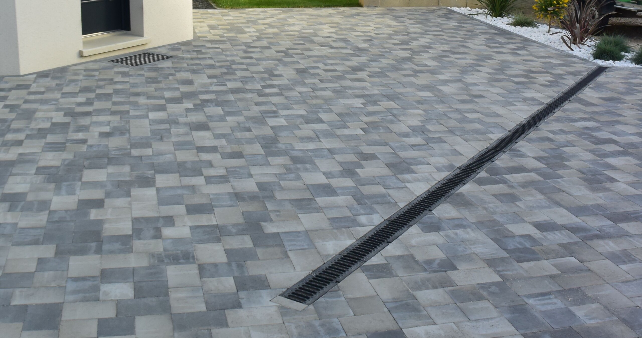 Terrasse en pavés de béton gris avec une grille d'évacuation