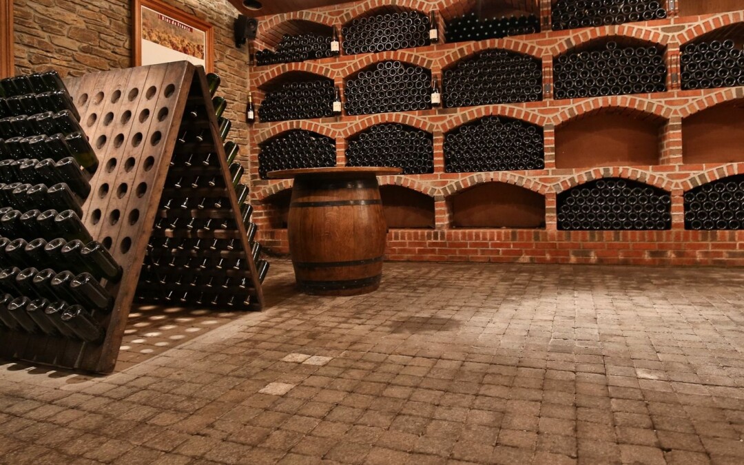 Cave à vin traditionnelle avec sol en pavés de béton et des étagères en briques