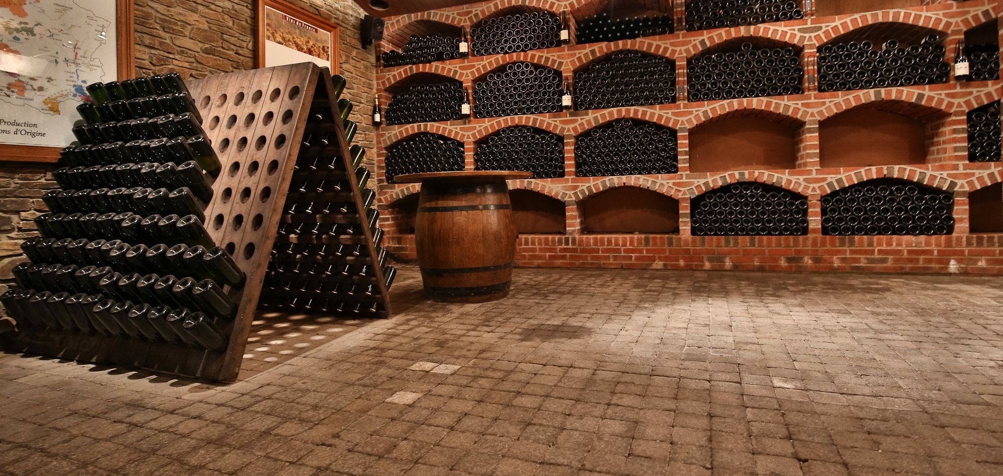 Cave à vin traditionnelle avec sol en pavés de béton et des étagères en briques