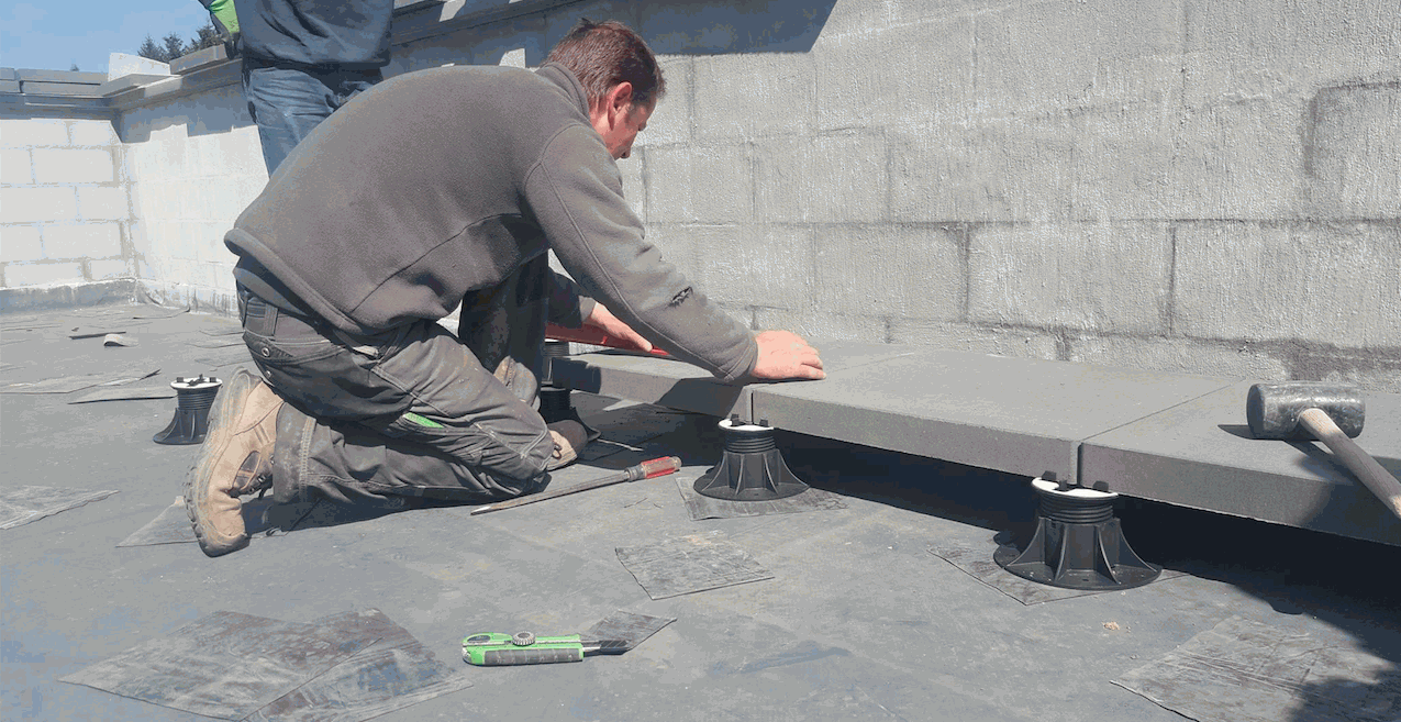 Un ouvrier pose des dalles en béton