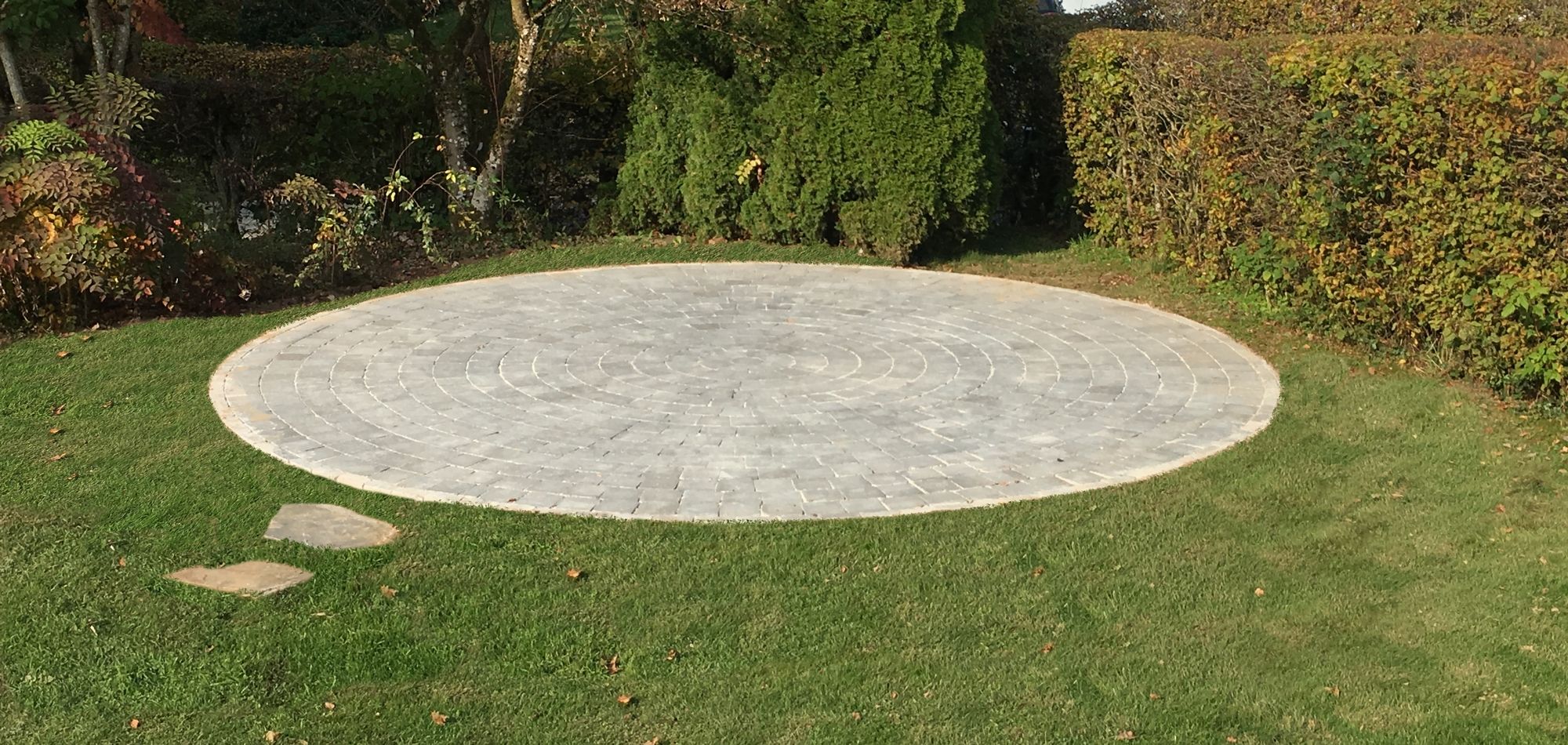 Une terrasse en cercle dont le sol est composé de pavés en béton