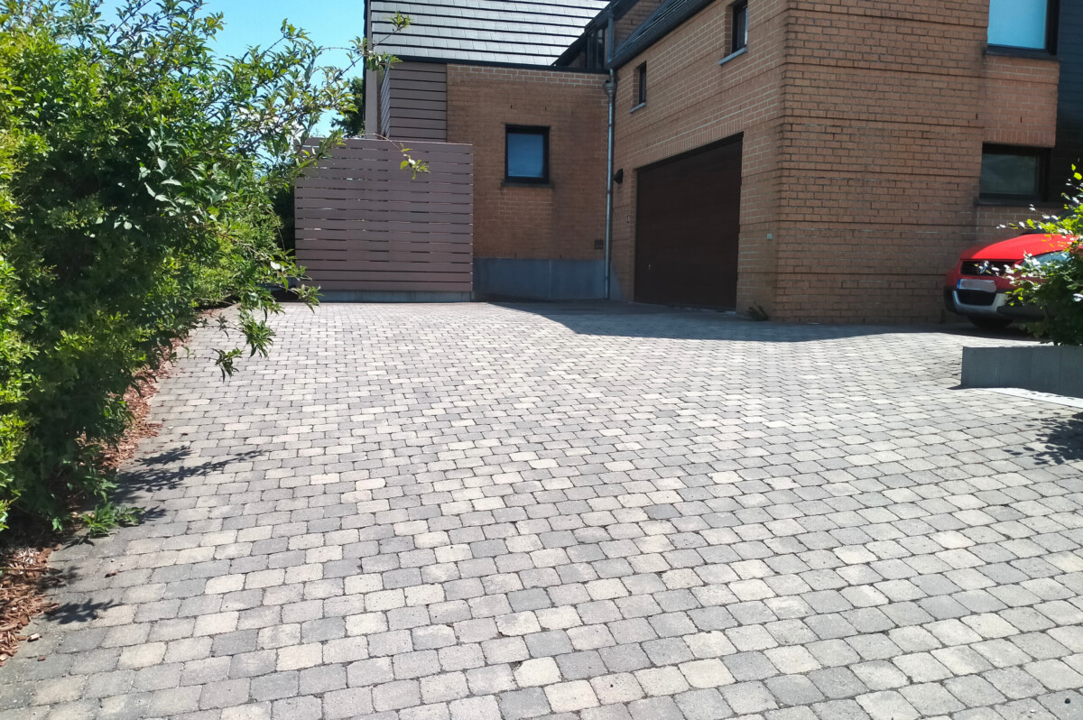 Allée de garage en pavés béton à l'avant d'une maison moderne.